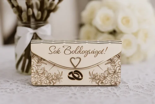 Lézergravírozott fa pénzátadó boríték esküvőre, részletgazdag virágmintákkal, szívvel és jegygyűrűkkel díszítve, elölről