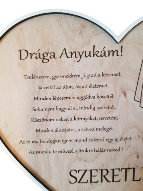 Szív alakú, gravírozott fa szülőköszöntő szív dísz.Közeli kép a feliratról.