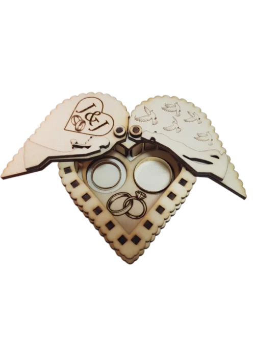 Natúrfa, nyitott. Szív alakú esküvői gyűrűtartó doboz, amely összezárva egy csókolózó párt formáz, egyedi monogrammal gravírozva.