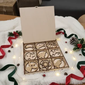 Nyitott karácsonyi díszdoboz 9 db fa dísszel, egy fehér szőrmén, ünnepi fényekkel körbevéve.