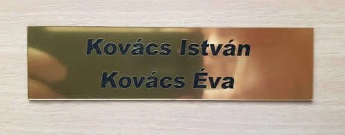 Arany-2 név - Arial Black_result Kétsoros, arany ajtónévtábla "Kovács István" és "Kovács Éva" nevekkel.