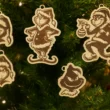 Grinch Ornaments on Tree__ Öt darabos Grincs karácsonyfadísz kollekció egy feldíszített fenyőfán, különböző Grincs arckifejezésekkel.
