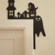Szellem-tökfej_result Fekete halloweeni dekoráció egy ajtó sarkán, amely egy kísértetkastélyt és egy szellemet ábrázol.